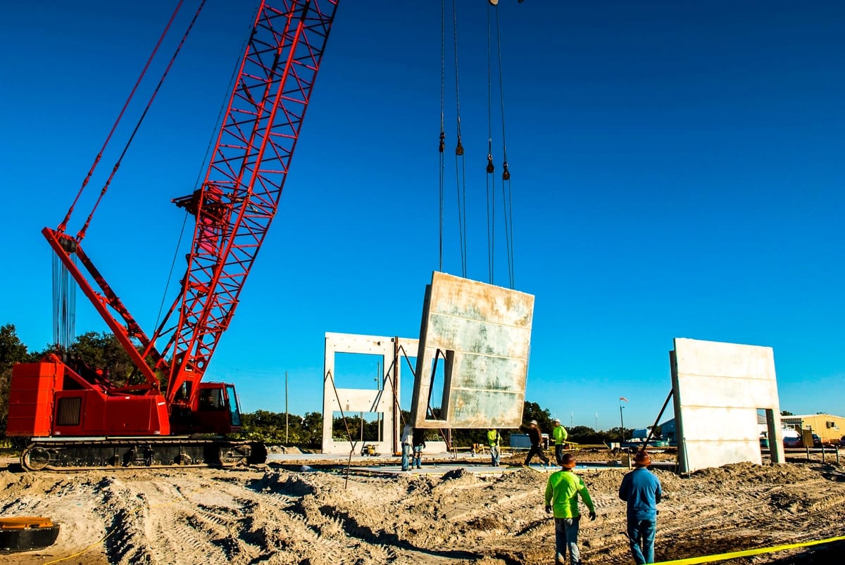 In Launch Complex 39 at NASA's Kennedy Space Center in Florida, workers guide one of the walls of the Propellants North Administrative and Maintenance Facility into place. Original from NASA. Digitally enhanced by rawpixel.